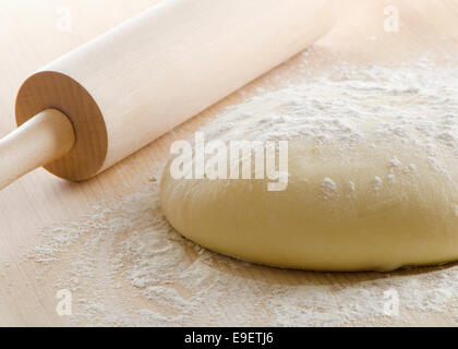 L'impasto con il mattarello sul tavolo di legno. Messa a fuoco selettiva Foto Stock