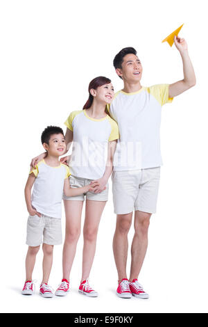 Felice famiglia giovane giocando con aeroplano di carta Foto Stock