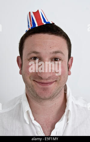 Un uomo in una piccola unione jack hat con uno stupido sorriso Foto Stock