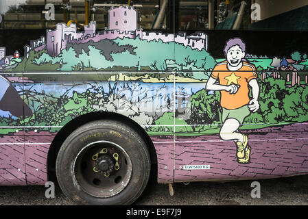 Attiva la parte maschio di un murale illustrativi sul lato di un servizio pubblico di autobus in Tenby REGNO UNITO Foto Stock