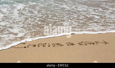 Caraibi scritto in sabbia con mare surf Foto Stock