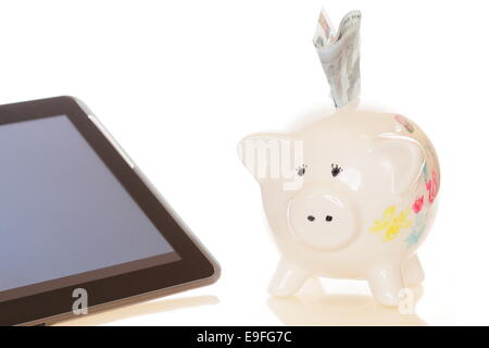 Tablet e piggybank Foto Stock