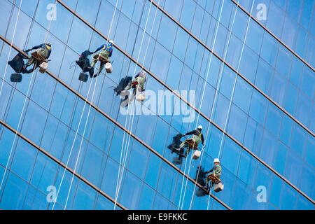 Operai pulire le finestre come un team su un grattacielo nel centro di Seoul, Corea del Sud Foto Stock