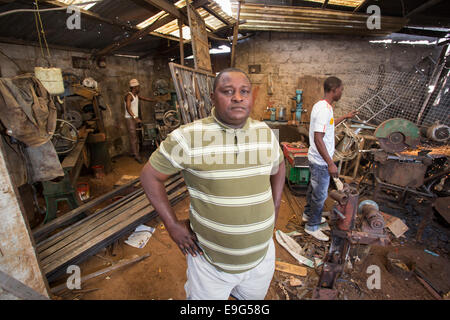 Bossman di un metallo workshop a Dar es Salaam, Tanzania Africa Orientale. Foto Stock