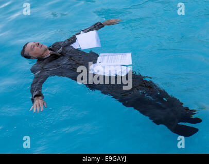 Senior man floating tra carte in acqua Foto Stock