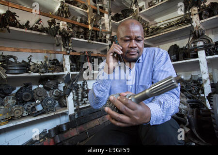 Parti automobilistiche venditore sul telefono mobile ad Arusha in Tanzania, Africa orientale. Foto Stock