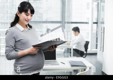 Incinta imprenditrice che detengono un portafoglio Foto Stock