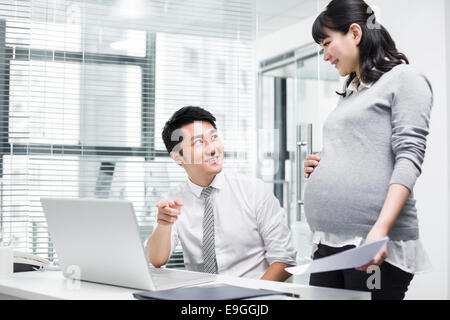 Incinta imprenditrice lavora con un collega Foto Stock