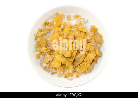 Primo piano di fiocchi di mais e il latte in una ciotola visto dal di sopra, isolato su sfondo bianco Foto Stock