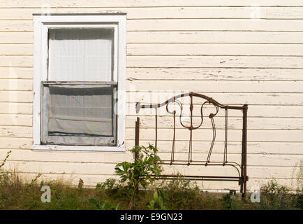 Un vecchio arrugginito testata giace contro una casa di legno in argento isolotto, Ontario, Canada Foto Stock