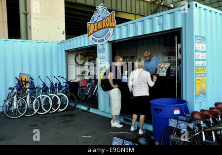NYC: coppia in attesa di noleggiare una bicicletta presso la bici e Roll rent shop in Riverside Park South Foto Stock