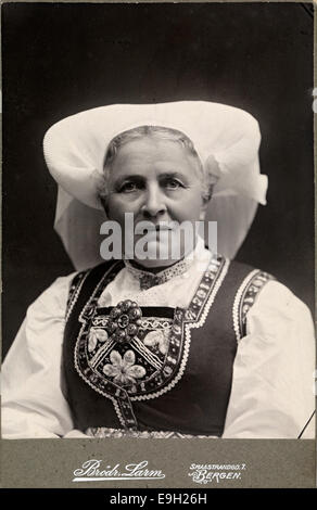 Questa fotografia raffigura una donna di Hardanger, Norvegia, che indossa un tradizionale costume popolare "bunad". L'immagine è stata scattata come un ritratto a tessera, catturando l'abbigliamento regionale e il significato culturale della regione di Hardanger. Foto Stock