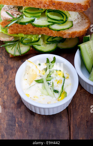 Freschi sandwich vegetariano con aglio formaggio insalata dip sul tavolo rustico Foto Stock