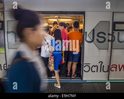 Bangkok, Tailandia. 28 ott 2014. Passeggeri scendere e lo Skytrain presso la Saphan Taksin station. Lo Skytrain (denominata BTS) sistema ha una lunghezza complessiva di 36 chilometri e comprende 34 stazioni compresa Saphan Taksin. Mentre ci sono due binari del treno per la maggior parte dei tratti del sistema dello Skytrain, la porzione a Saphan Taksin ponte che attraversa il fiume Chao Phraya ha solo una via a causa dello spazio limitato, causando un collo di bottiglia quando un treno in uscita e in entrata il treno arriva in corrispondenza del ponte allo stesso tempo. Credito: ZUMA Press, Inc./Alamy Live News Foto Stock