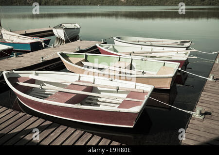 Floating barche di legno con le pale e la sua riflessione in un'acqua. Filtrata shot Foto Stock