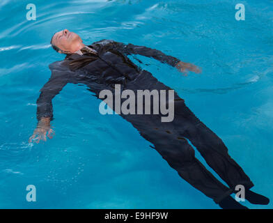 Senior uomo galleggiante sul retro in acqua Foto Stock