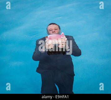 Senior man holding salvadanaio sopra l'acqua Foto Stock