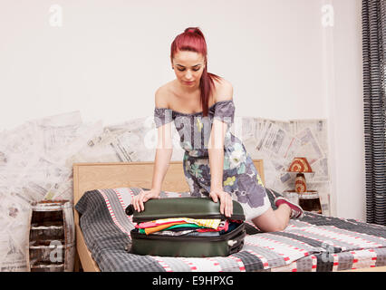 Attraente bella donna abiti da imballaggio in bagagli nella sua camera da letto Foto Stock