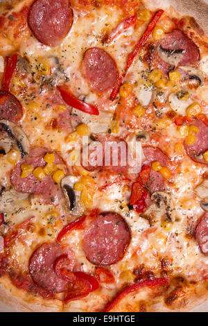 Una gustosa pizza italiana con salsiccia per pizza e funghi, vista dall'alto Foto Stock