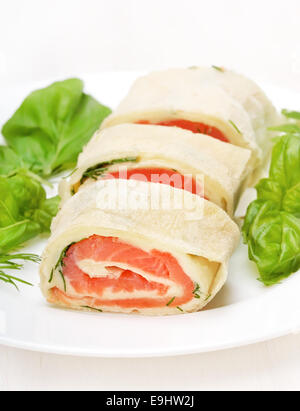 Salmone rotoli lavash con formaggio ed erbe su piastra bianca Foto Stock