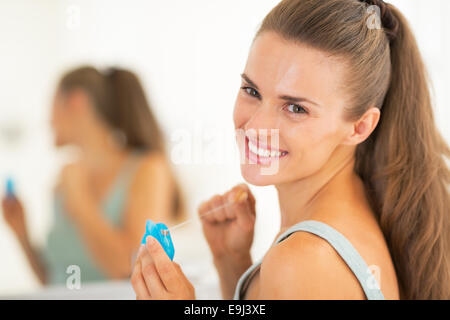 Ritratto di felice giovane donna con filo interdentale Foto Stock