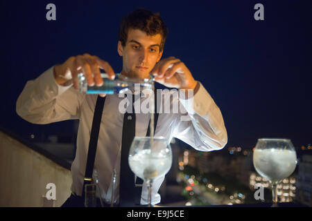 Un cameriere prepara cocktail al cameriere Casa Mila, La Pedrera, skyline di Barcellona, Spagna. Per i camini. Panorama del tetto Foto Stock