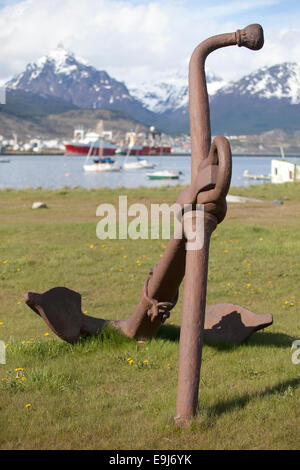 Un arrugginito ancoraggio nel porto di Ushuaia con le montagne innevate sullo sfondo. Tierra del Fuego, Argentina. Foto Stock