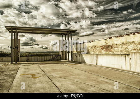 Una scala coperta al piano superiore di un garage per il parcheggio con una bella miscelati nube riempiva il cielo in background. Foto Stock