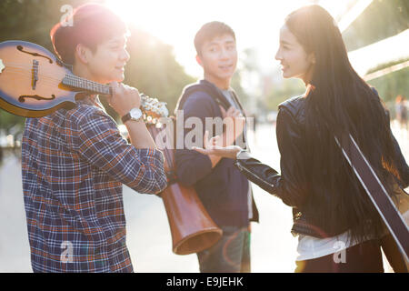 I giovani adulti con attrezzature musicali lasciando Foto Stock