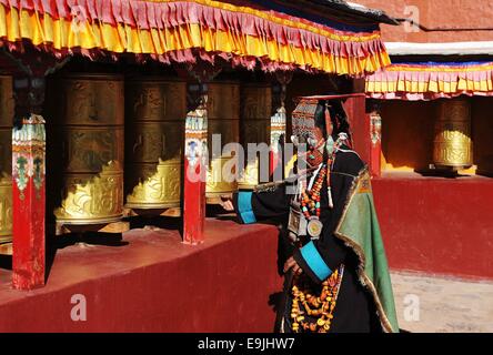 (141029) -- BURANG, Ottobre 29, 2014 (Xinhua) -- una donna che indossa il costume Burang ruotare le ruote di preghiera al villaggio Kegya Burang nella contea di Nagri Prefettura, a sud-ovest della Cina di regione autonoma del Tibet, Ottobre 23, 2014. Burang costume che ha una storia di più di mille anni, è famoso per i suoi lussuosi accessori. Centinaia di pezzi di cera d'api, numerose perle e kallaties, ammassata coralli rossi e delicato argento e decori in oro comporre di inestimabile suite. Sette famiglie a Kegya villaggio hanno conservato sette tute di costumi Burang tramandata dagli antenati. (Xinhua/Wen Tao) (lfj) Foto Stock