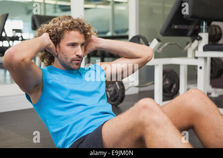 Uomo bello facendo sgranocchia addominale in palestra Foto Stock