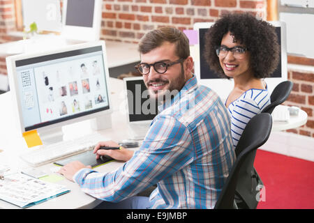 Sorridendo gli editor di foto utilizzando il digitalizzatore in office Foto Stock