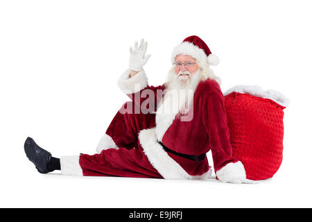 Santa siede appoggiò sulla sua borsa e onde Foto Stock