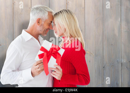 Immagine composita di amare giovane con dono Foto Stock