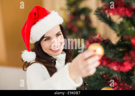 Happy brunette decorare un albero di natale Foto Stock