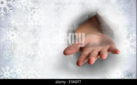 Immagine composita di mano lo scoppio attraverso la carta Foto Stock