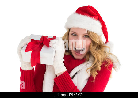 Santa bella ragazza sorridente in telecamera tenendo dono Foto Stock