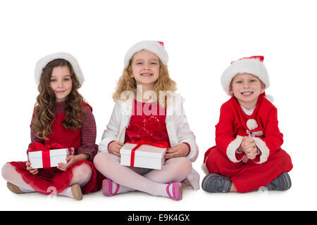 Festive piccoli fratellini sorridente in telecamera tenendo doni Foto Stock