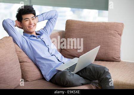 Felice giovane uomo con il computer portatile Foto Stock