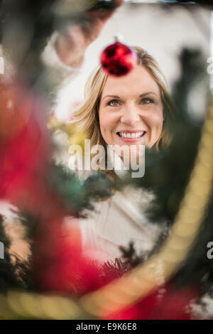 Festive blonde hanging ninnolo su albero di natale Foto Stock