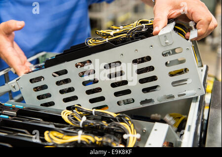 Sezione mediana del tecnico maschio esaminando la scheda video nel computer industria manifatturiera Foto Stock