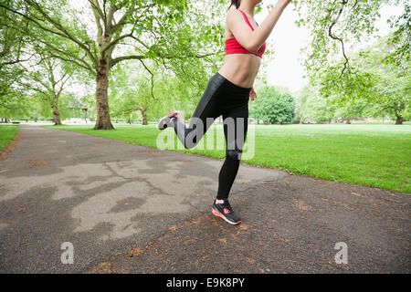 Sezione bassa della giovane donna a fare jogging nel parco Foto Stock