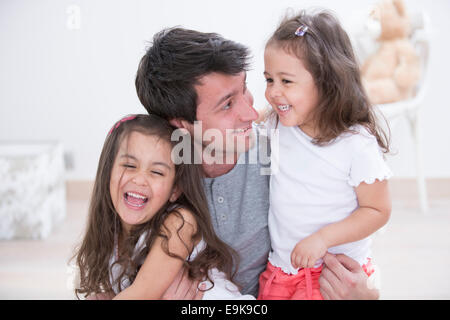 Padre Felice con le figlie trascorrere del tempo di qualità insieme a casa Foto Stock