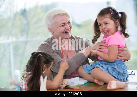 Felice senior donna avente il tempo di qualità con nipoti a casa Foto Stock