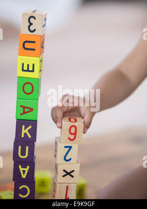 Close-up della ragazza che gioca con blocchi a casa Foto Stock