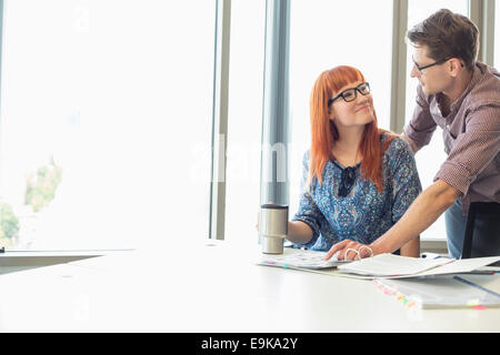 Gli imprenditori che cercano in ogni altro mentre si lavora alla scrivania in ufficio creativo Foto Stock