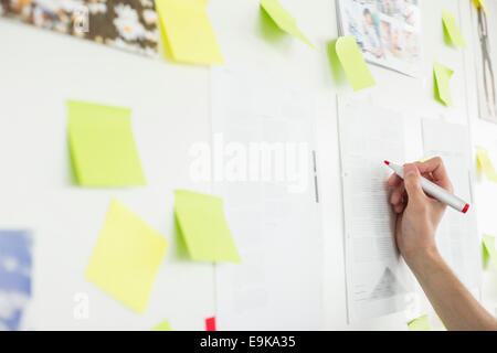 Immagine ritagliata di imprenditore il la scrittura a mano su un foglio di carta in ufficio Foto Stock