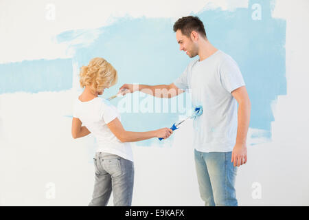 Giocoso giovane pittura ogni altro nella nuova casa Foto Stock