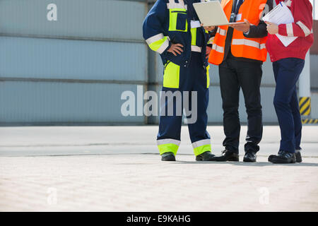 Sezione bassa dei lavoratori di discutere in cantiere di spedizione Foto Stock