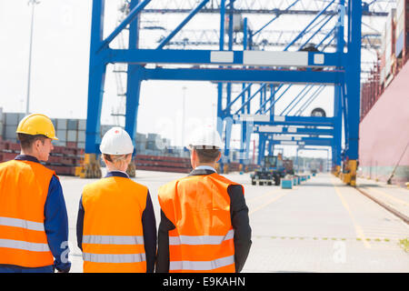 Vista posteriore dei lavoratori a piedi in cantiere di spedizione Foto Stock